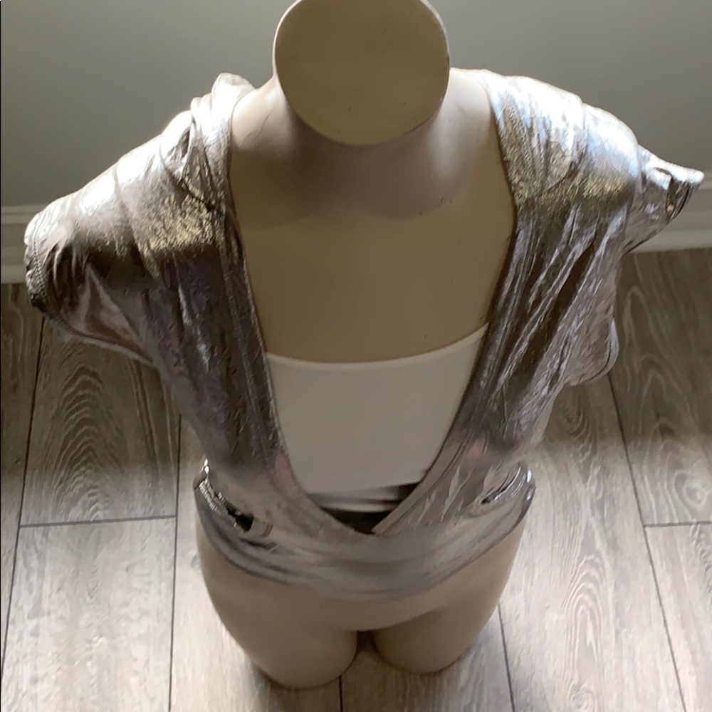 Silver top with a cream cami underneath.